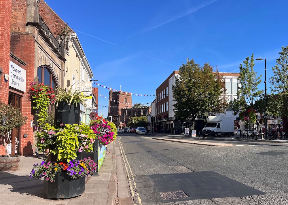 Newport High Street in Shropshire with St Nicholas Church and hanging flower baskets